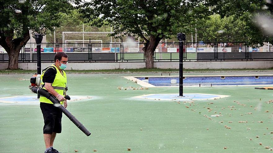 Un operari fent tasques de neteja a l&#039;entorn de les piscines de Sant Joan de Vilatorrada