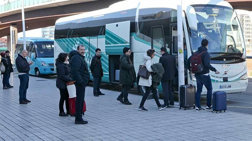 Pasajeros de uno de los trenes afectados, en la estación de Gijón, a punto de ser trasladados en autobús a sus destinos.