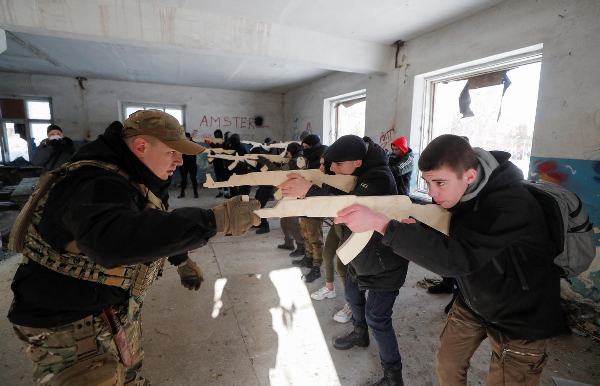 Civiles ucranianos armados con fusiles de madera juegan a la guerra en las ruinas de la antigua fábrica de tractores en Kiev, donde aprenden los rudimentos de la defensa de la ciudad en caso de invasión rusa.