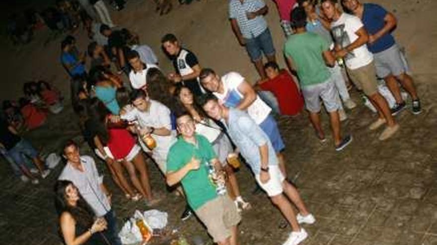 Algunos jóvenes beben en la zona del Golf de la playa de San Juan.