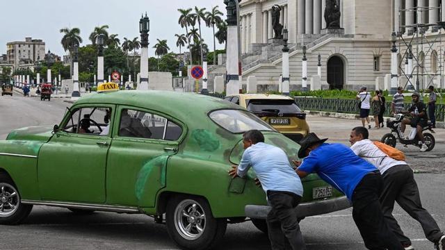 Unes persones empenyen un cotxe vell per un carrer de l’Havana la setmana passada.