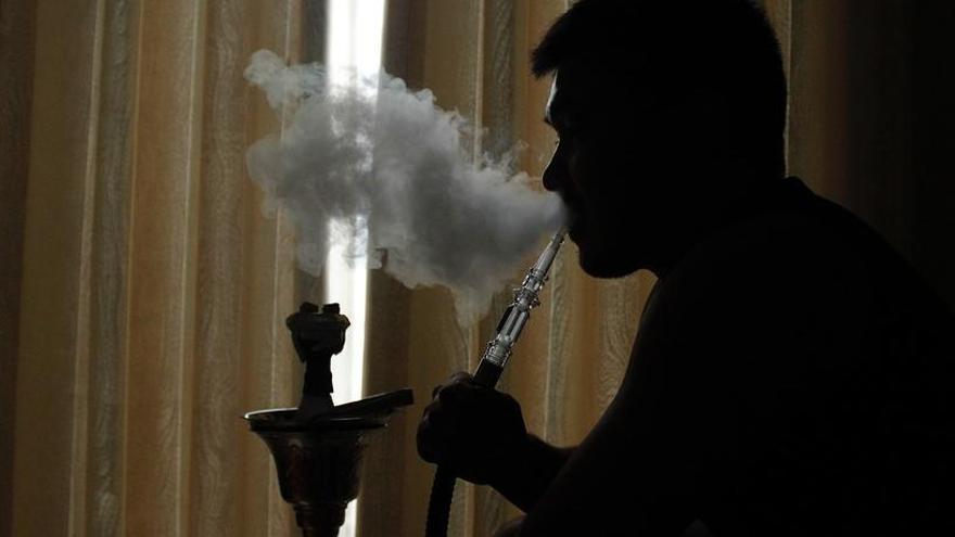 Un joven fumando tabaco en una cachimba.