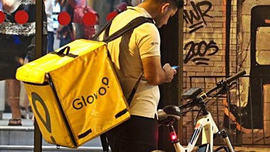 Un repartidor en bicicleta treballant per Glovo.