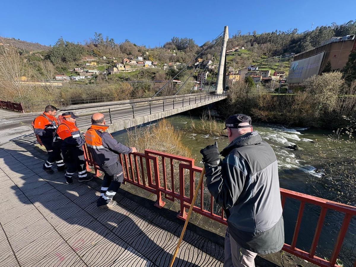 Voluntarios de Protección Civil del Alto Nalón escrutan el río en El Entrego