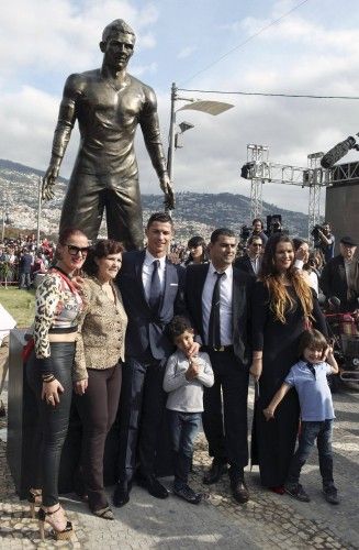 Portugal's Cristiano Ronaldo and his family members pose under his statue during the unveiling of the statue at a tribute ceremony held in Funchal