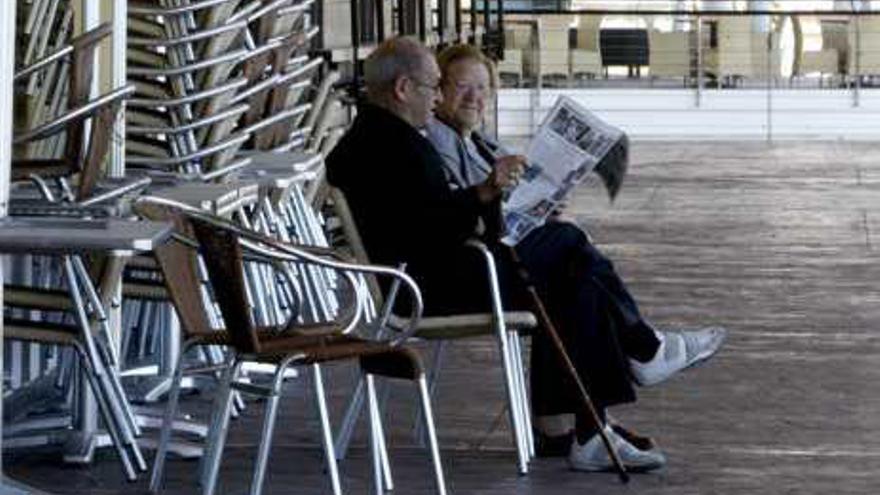 Una pareja lee el diario en el exterior de Panoramis.