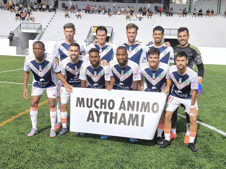 Once inicial del San Fernando con una pancarta para enviar ánimos al lesionado Aythami Betancor.