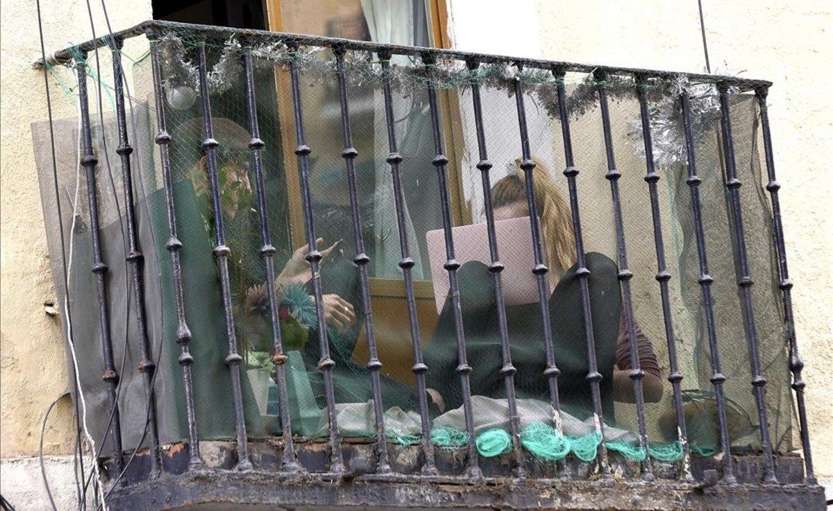 Una pareja en un balcón del barrio de Lavapiés, Madrid, durante el confinamiento.