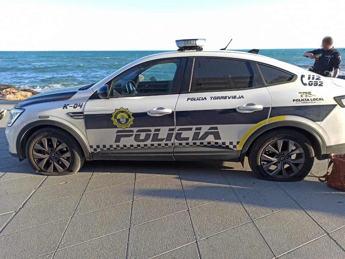 Coche patrulla de la Policía Local con las ruedas rajadas en el paseo de Juan Aparicio de Torrevieja