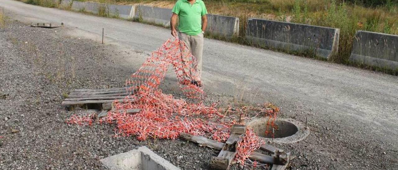 César Solís muestra el cierre de protección roto y las arquetas descubiertas en San Miguel de la Barreda.