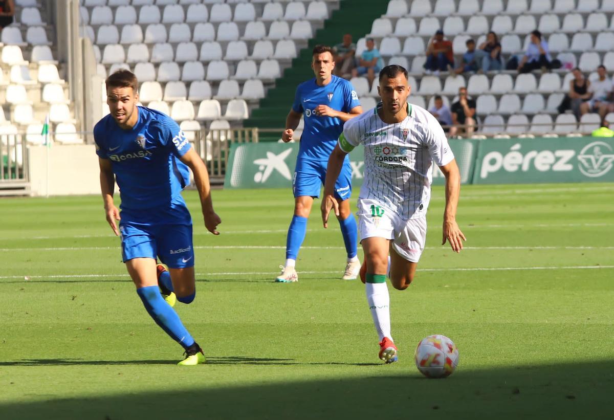 De las Cuevas corre por un balón junto a un defensor azulino, este domingo, durante el Córdoba CF - San Fernando.