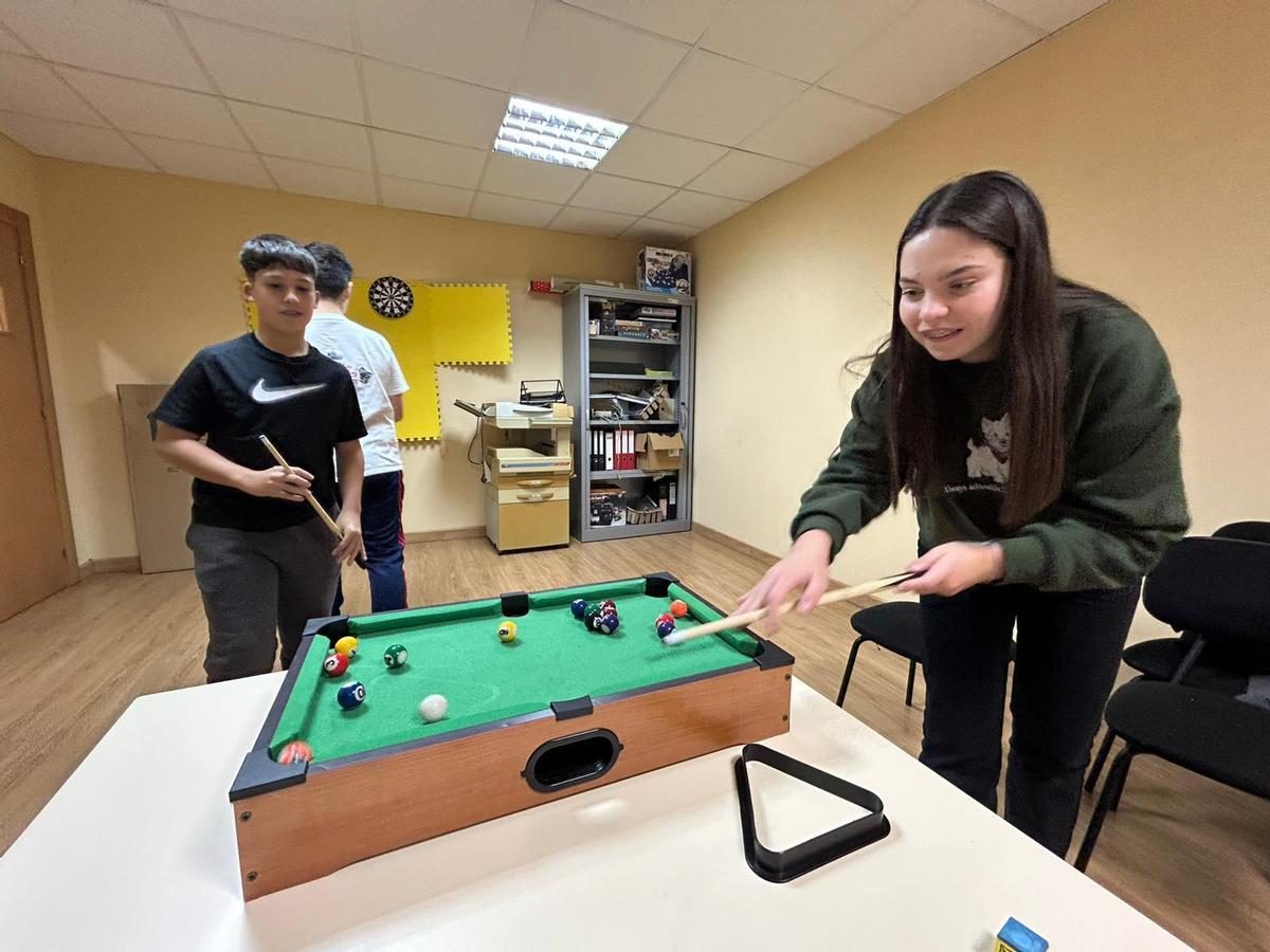 Fabián Díaz y Celia Fernández, jugando al billar en el local.