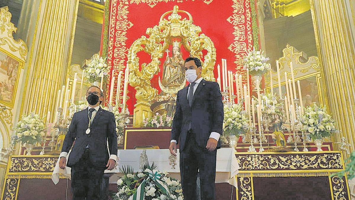 El presidente de la Junta participa ayer en la ofrenda de flores a la Virgen de la Victoria, en Málaga.