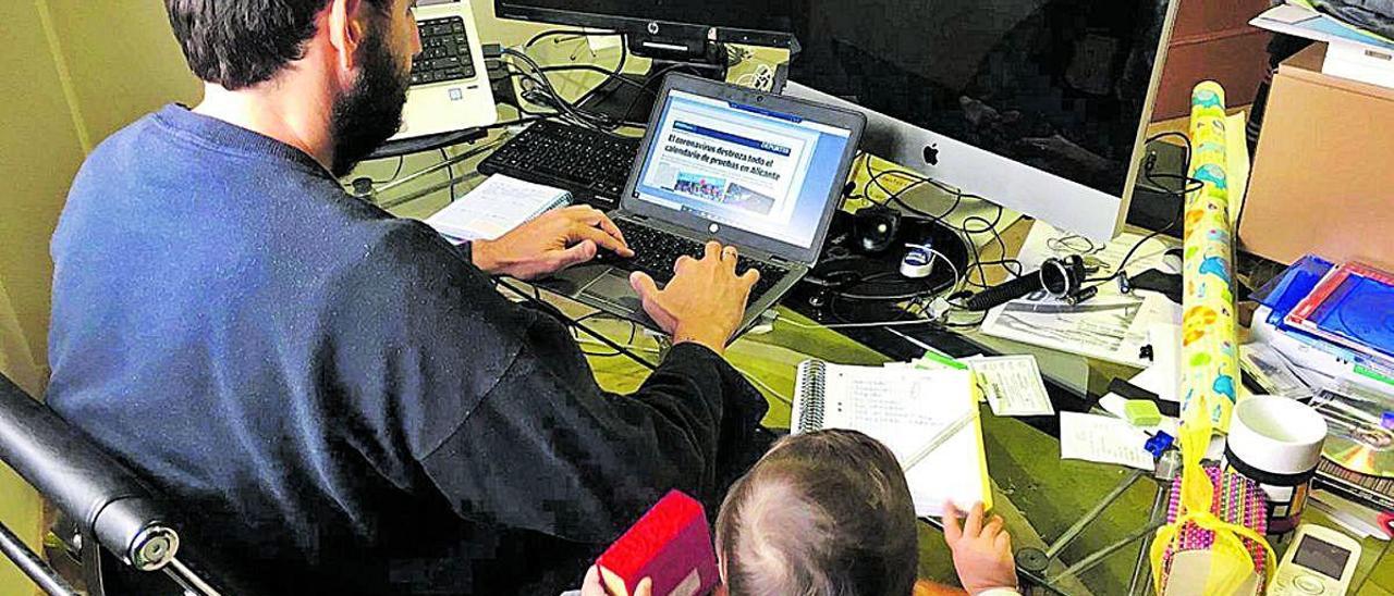 Un hombre trabajando desde casa con un hijo pequeño.