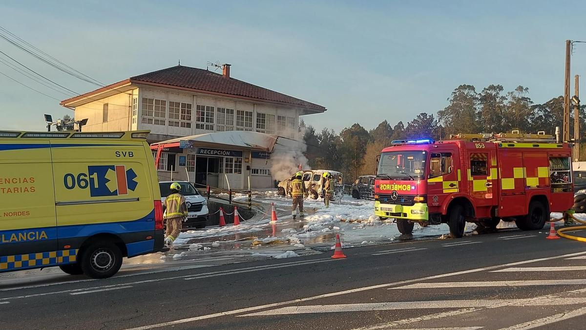 Los bomberos apagando las llamas de los vehículos incendiados en Lavacolla