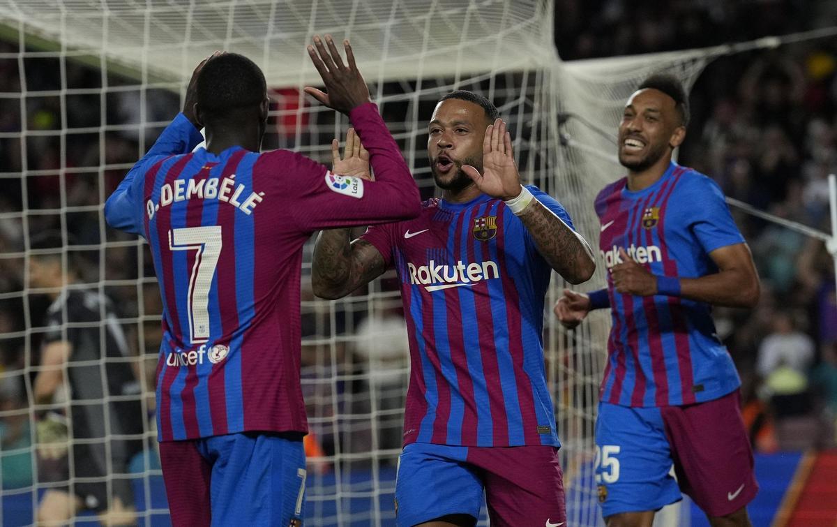 BARCELONA, 10/05/2022.- El centrocampista del FC Barcelona Memphis Depay (c) celebra con Ousmane Dembelé (i) y Pierre-Emerick Aubameyang tras marcar ante el Celta, durante el partido de Liga en Primera División ante el Celta que se disputa hoy martes en el Camp Nou, en Barcelona. EFE/Alejandro García