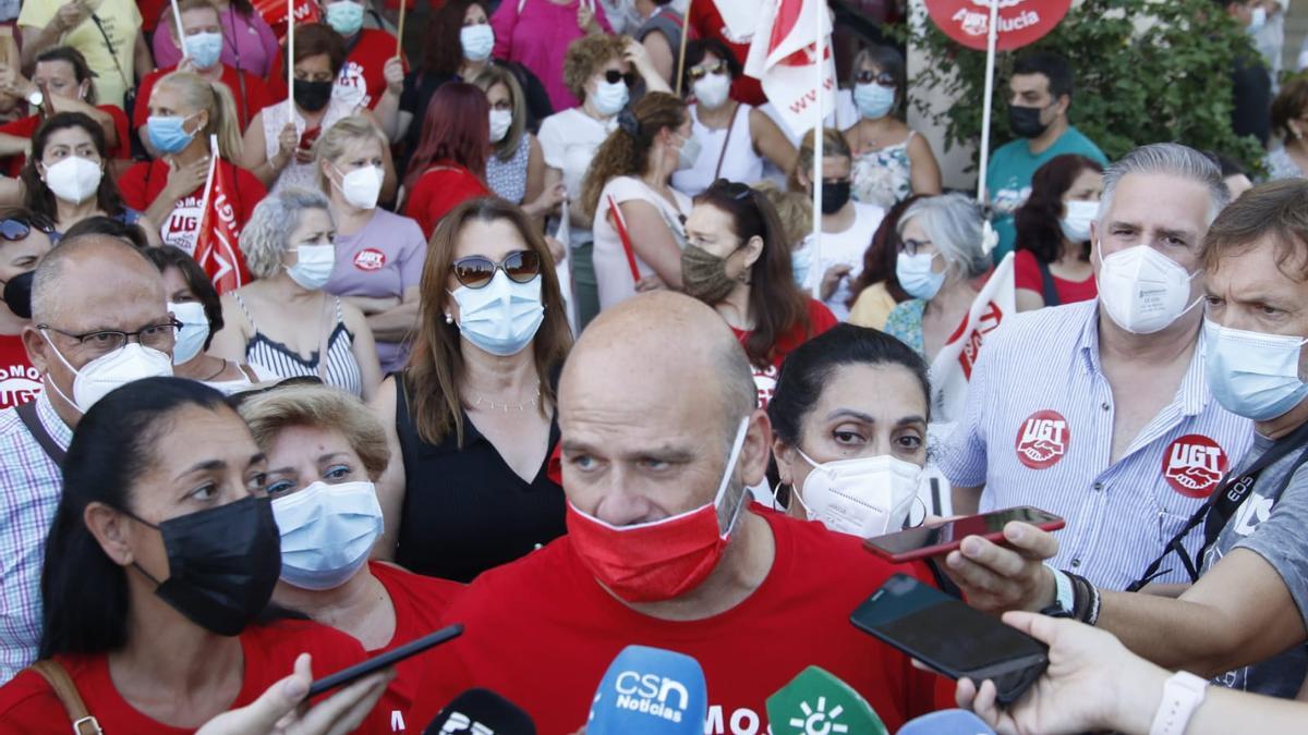 Juan Martínez atiende a los medios con las trabajadoras de la limpieza concentradas de fondo