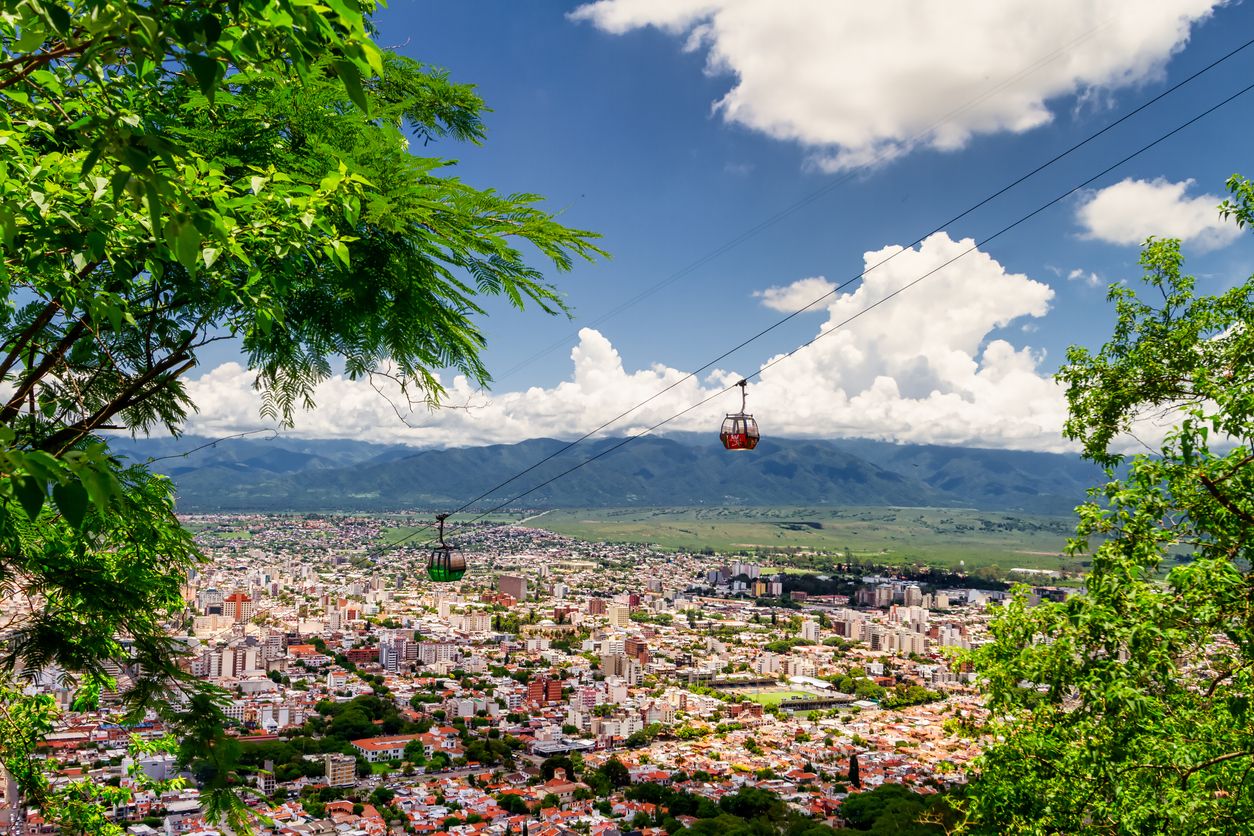 Dos teleféricos se cruzan en el cerro San Bernardo con la capital de la provincia norteña al fondo.