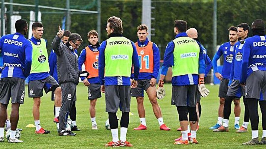 Keko y Vallejo, con peto naranja, escuchan junto a sus compañeros las instrucciones de Fernando Vázquez ayer en Abegondo.