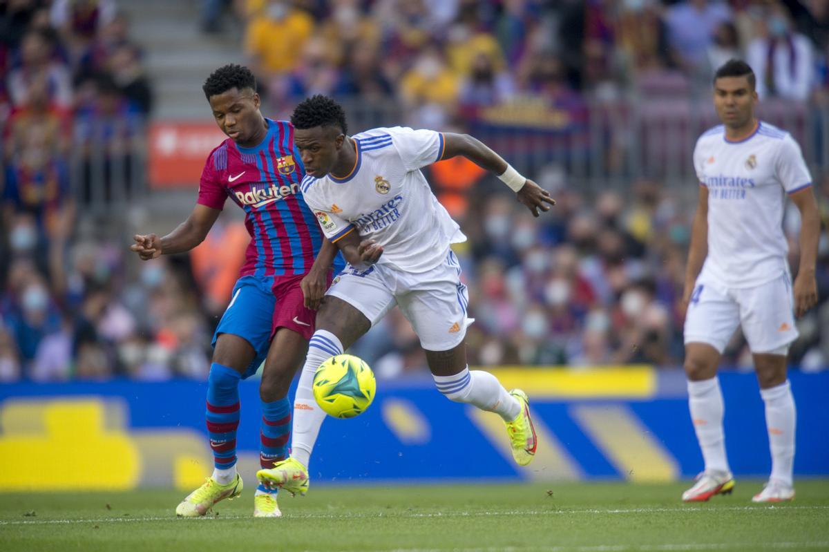 Ansu Fati y Vinicius tras un balón 