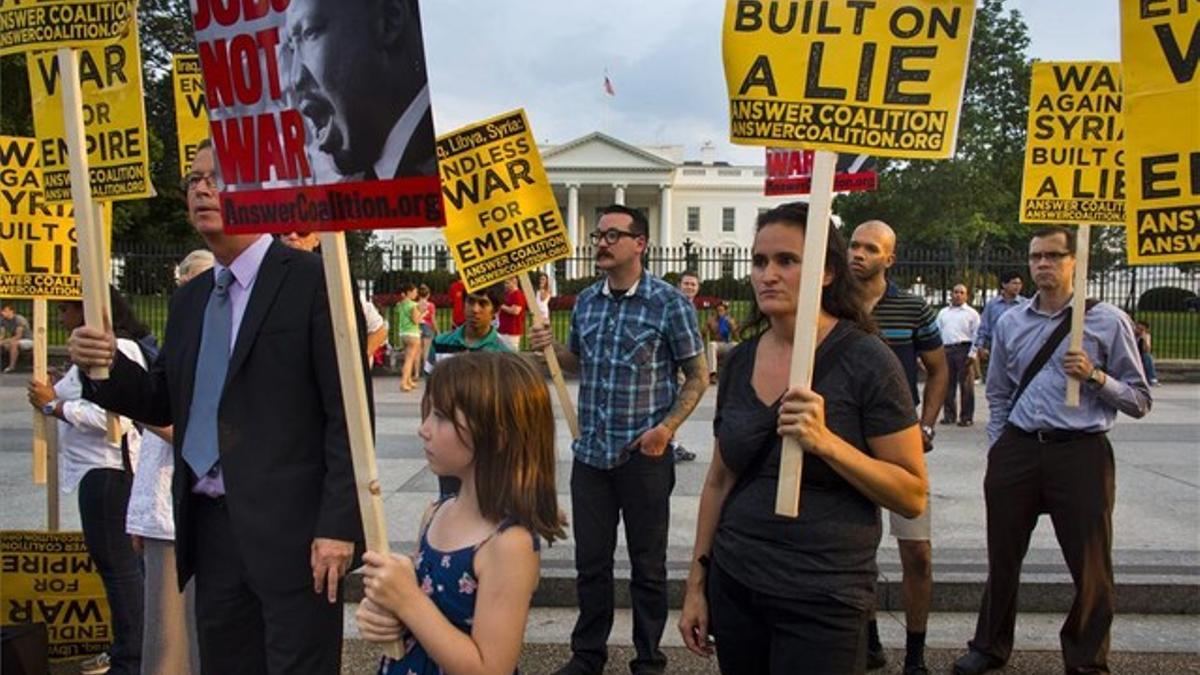 Pancartas de manifestantes ante la Casa Blanca sostienen que la guerra contra Siria se está construyendo con mentiras