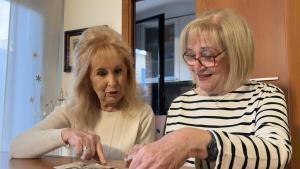 Roser Miquel y Victòria Brossa, mirando las fotos de las antiguas casas que ocupan el actual edificio donde viven