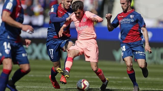 Riqui Puig se cuela entre Rivera y Miramon, del Huesca, en El Alcoraz.
