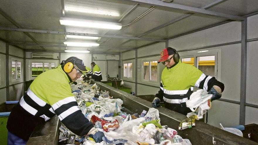 Dos operarios  trabajan en la separación de residuos.