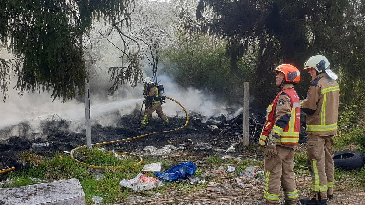 Los bomberos junto al lugar en el que se declaró el incendio