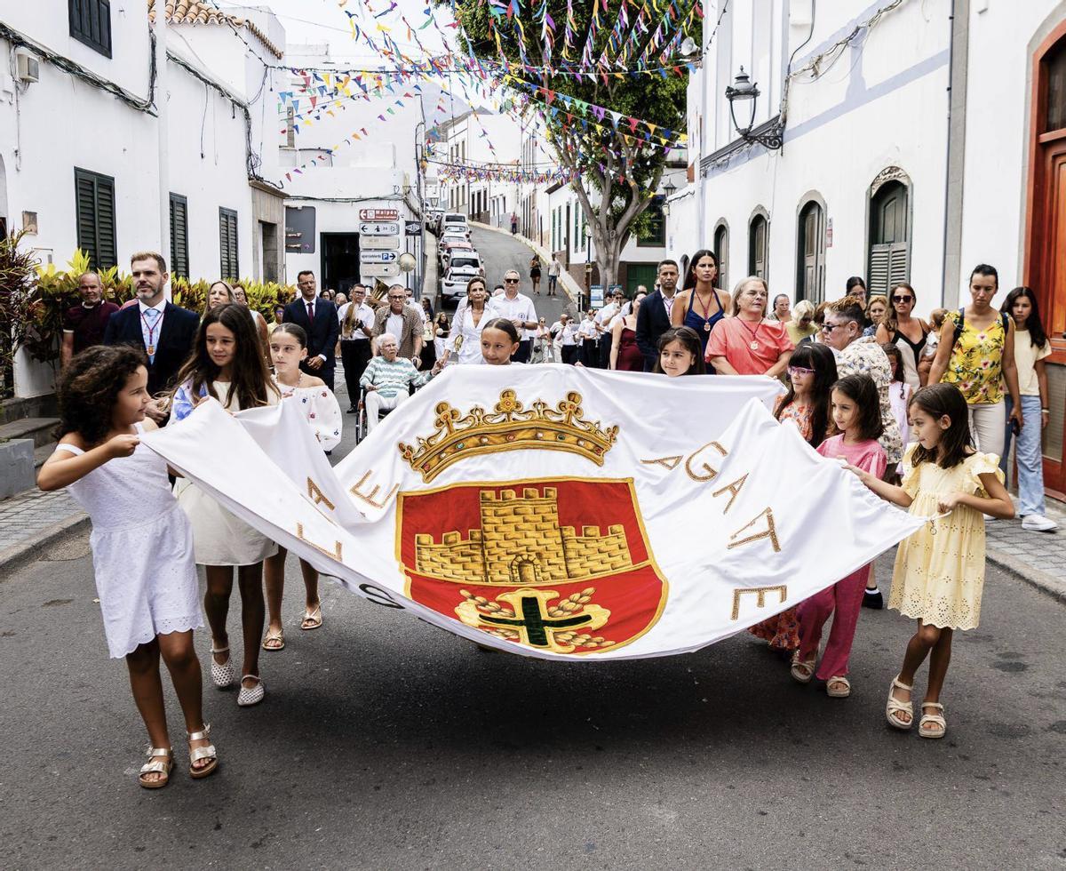 Las vecinas del pueblo trasladan la bandera antes del izado en Agaete. | LP/DLP
