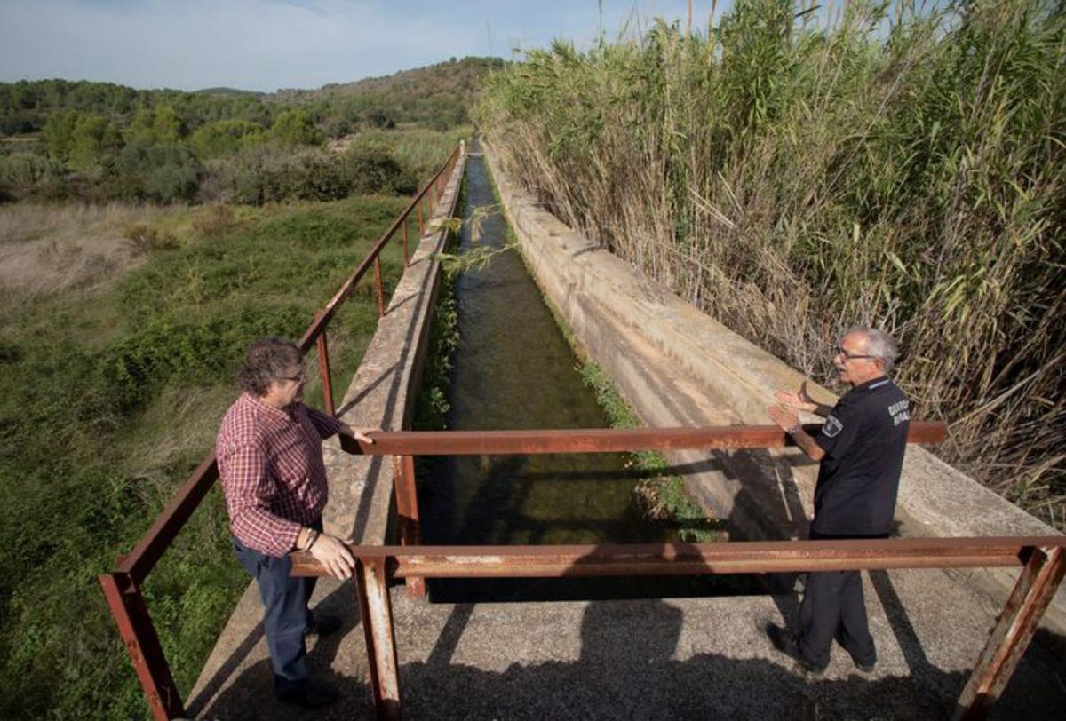 El alcalde y un agente, junto al canal y el abundante cañizo.