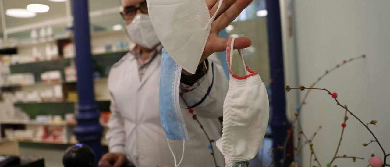 Javier Díez, con varios modelos de mascarillas en una farmacia avilesina.