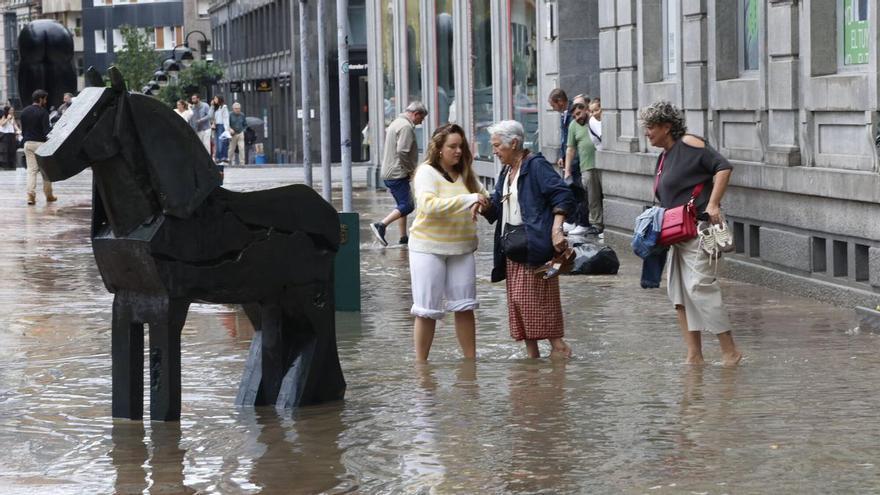Un diluvio colapsa Oviedo: calles convertidas en ríos, garajes anegados, comercios inundados, apagones y daños en el Palacio de los Deportes