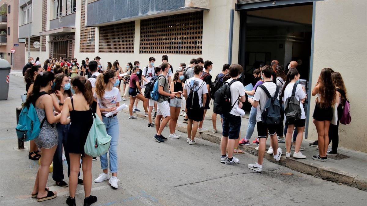 Un grupo de alumnos espera a las puertas del Col·legi Badalonès para hacer la selectividad.