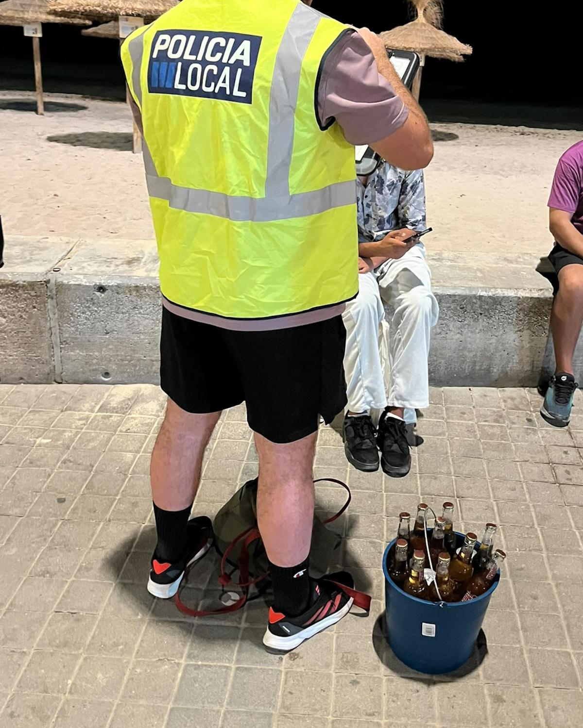 Un policía, con un vendedor que llevaba un cubo con cervezas.