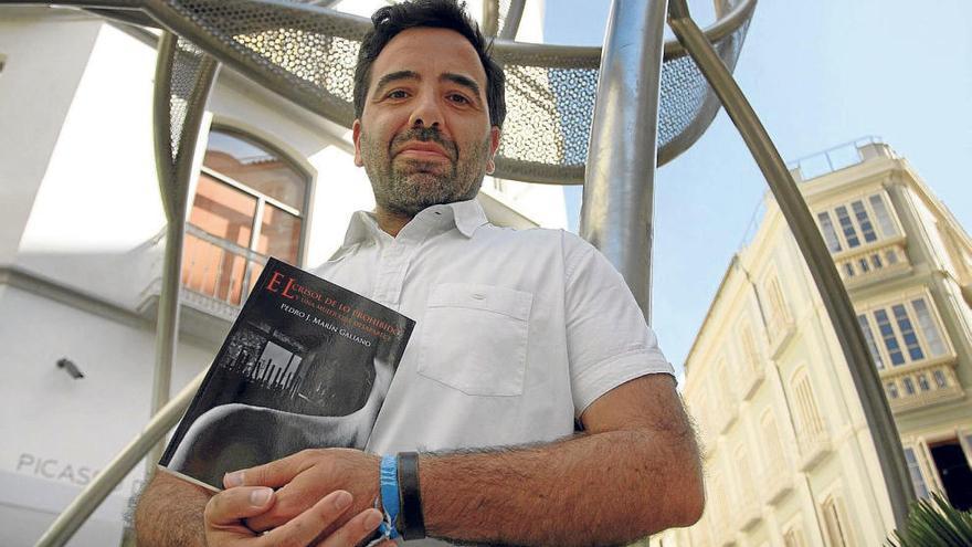 Pedro Marín posa con su novela negra en el Centro Histórico de Málaga.