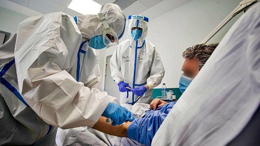 Dos sanitarios atienden a un paciente de covid-19 en el Hospital General de València.