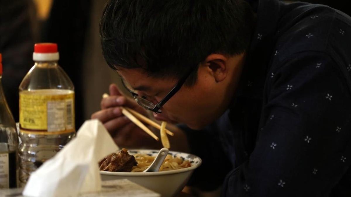 Un hombre asiático comiendo.