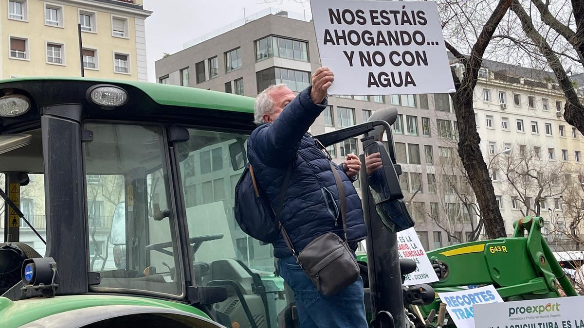 Un agricultor muestra un cartel alusivo en la concentración del miércoles en Madrid contra el recorte del Tajo-Segura.