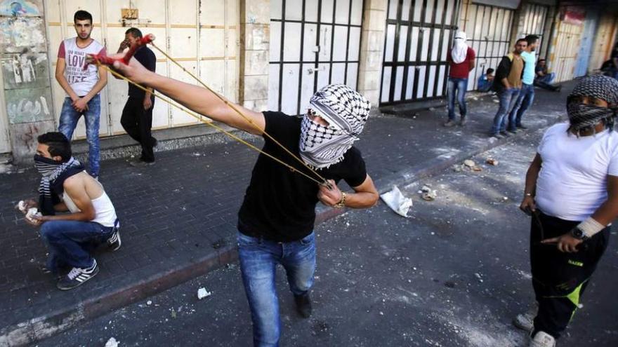 Manifestantes palestinos arrojan piedras contra soldados israelíes en la ciudad cisjordana de Hebrón.