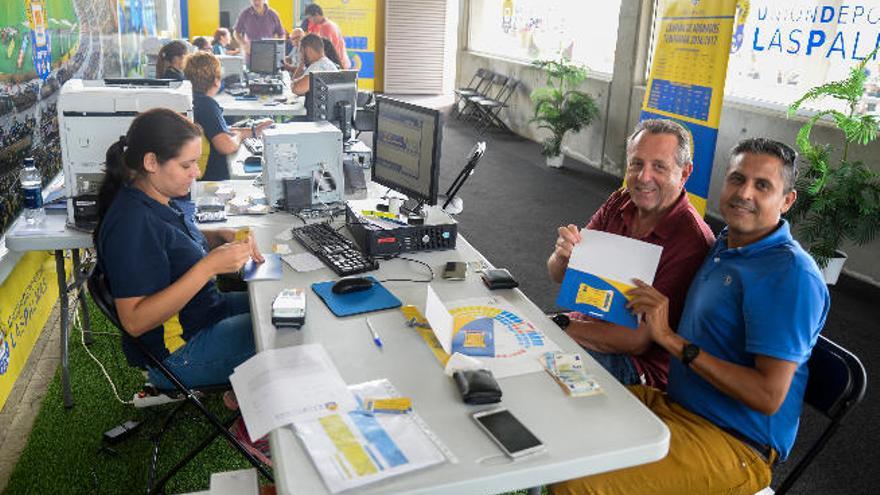 Los aficionados José María y Alberto posan con su abono para la próxima temporada.