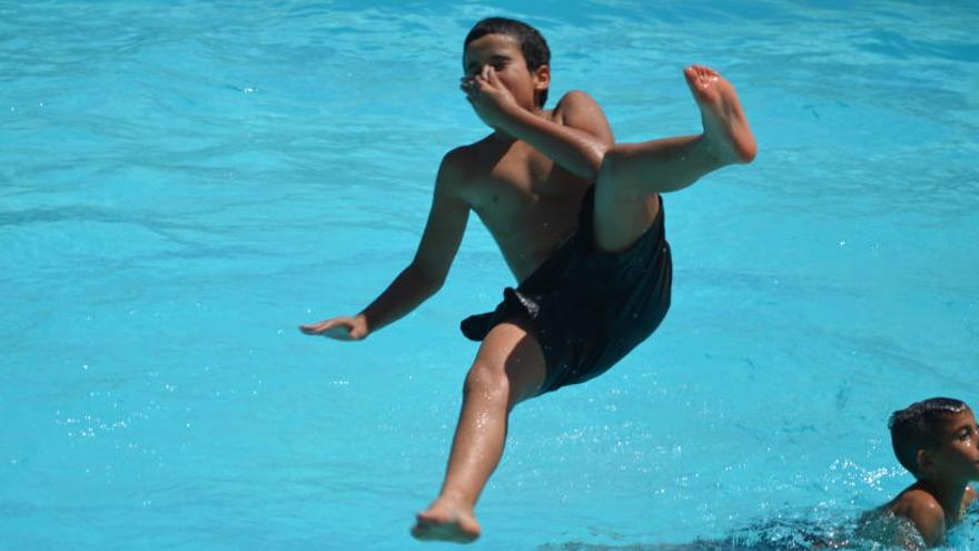 Un nen es llança a la piscina.