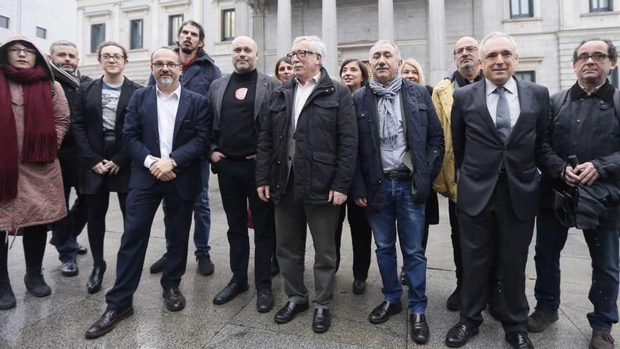 Ignacio Fernández &quot;Toxo&quot;, de Comisiones Obreras, y el secretario general de UGT, el asturiano Pepe Álvarez, en el centro de la foto, ayer a las puertas del Congreso, junto a representantes de los grupos que promovieron y respaldaron la iniciativa popular para implantar la renta mínima.