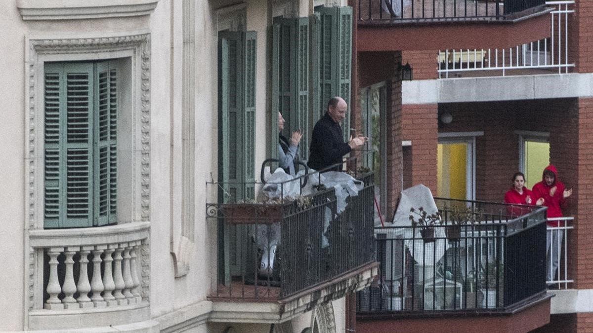 Personas aplauden desde los balcones del Eixample, el 30 de marzo del 2020