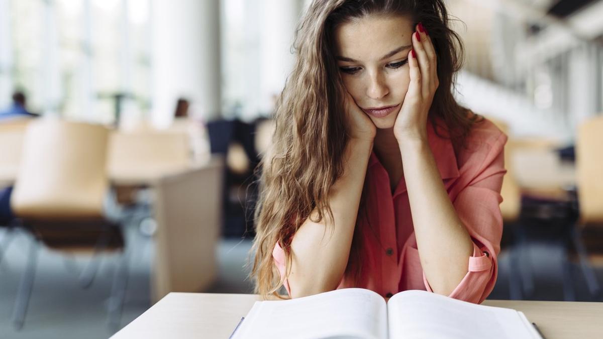 Mujer estudiando en la biblioteca.