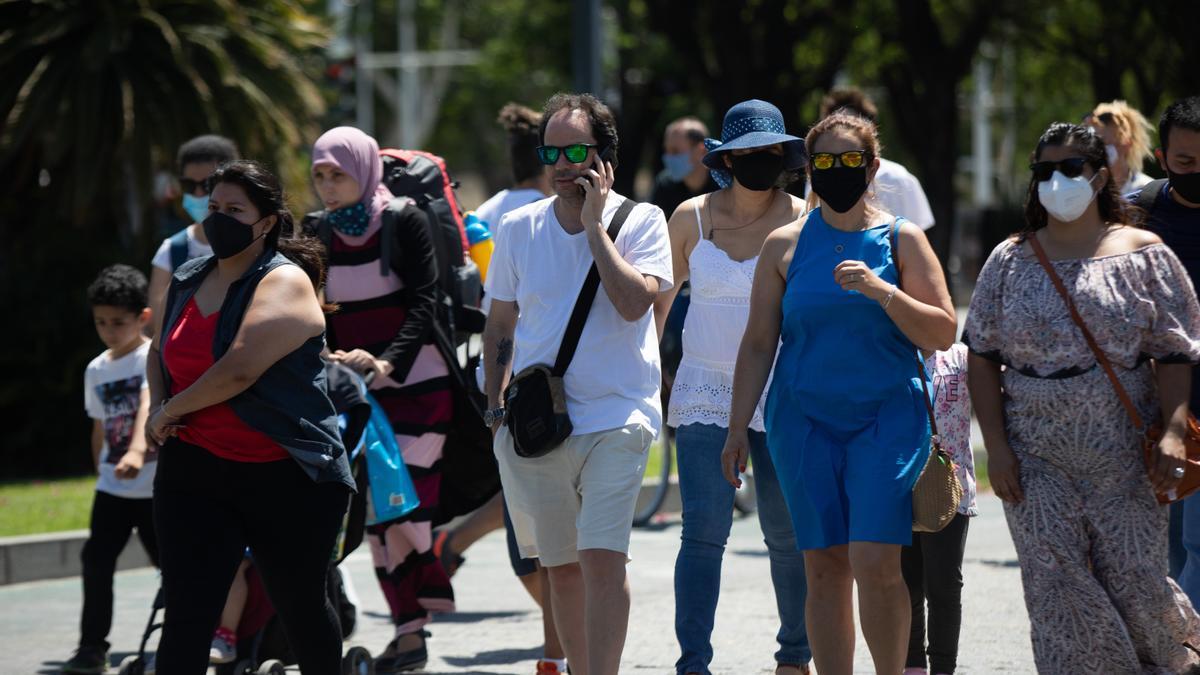 Un grupo de personas pasea por Sevilla, algunos con y otros sin mascarillas.