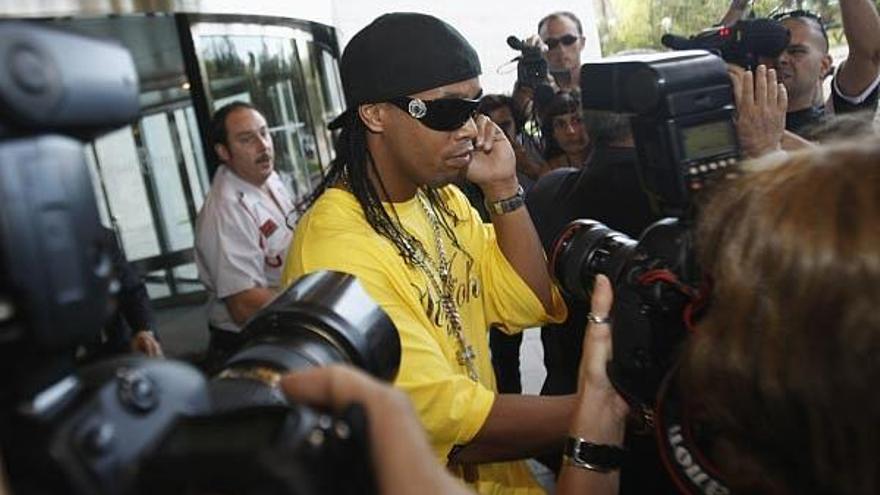 Ronaldinho es escoltado a su salida del hotel en la tarde de ayer en Barcelona. /