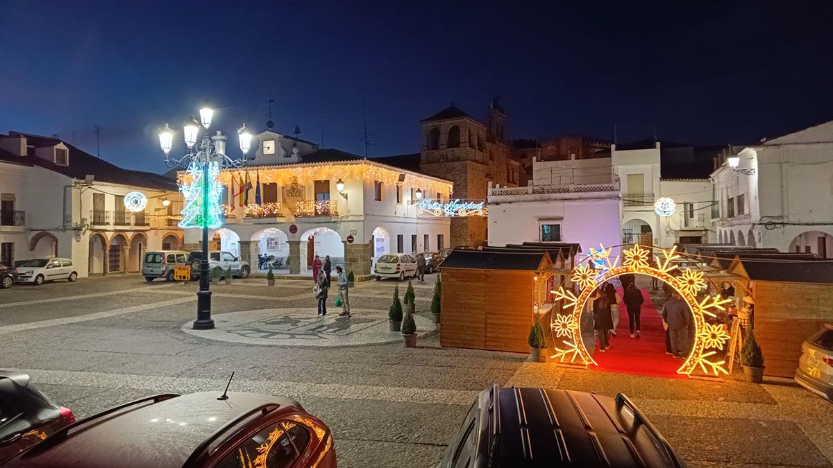 La plaza de Segura de León al anochecer, con su iluminación festiva y las casetas de madera que dan vida al mercadillo durante todos los fines de semana de diciembre