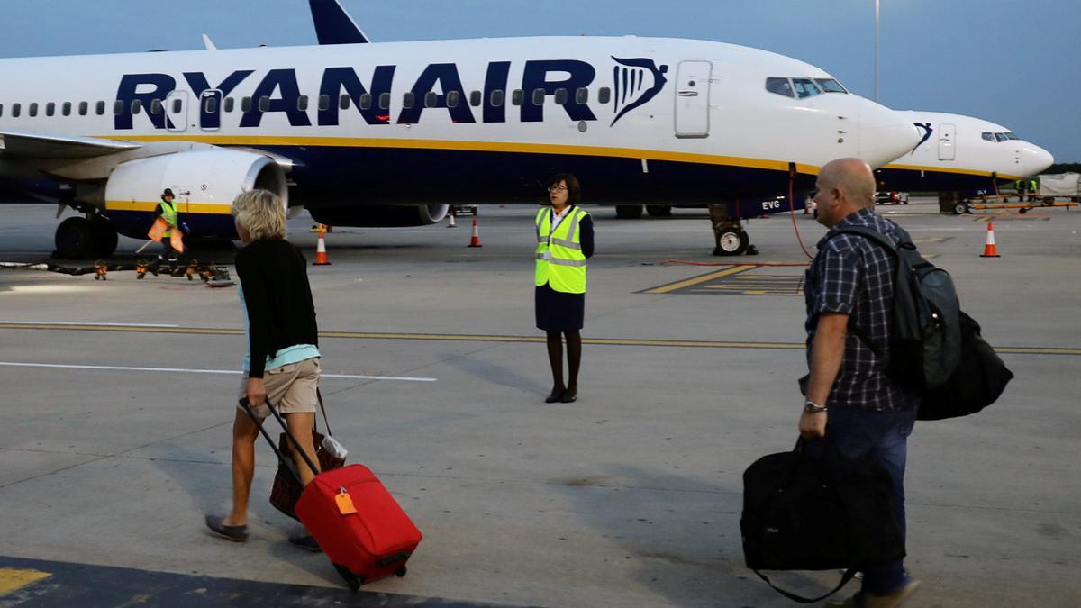 FILE PHOTO: People walk to board a Ryanair flight at Stansted Airport, northeast of London, Britain