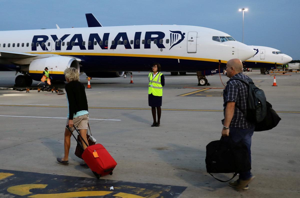 FILE PHOTO: People walk to board a Ryanair flight at Stansted Airport, northeast of London, Britain, September 7, 2017. Picture taken September 7, 2017.  REUTERS/Kevin Coombs/File Photo